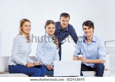 Four co-workers discussing business ideas in office
