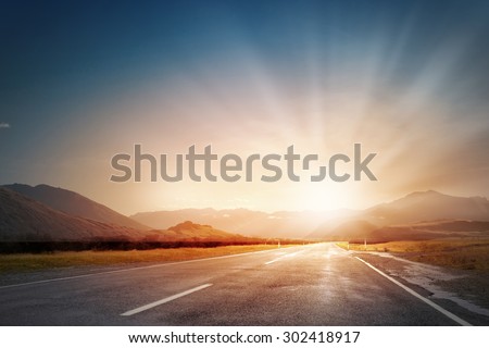 Empty asphalt road and sun rising at skyline