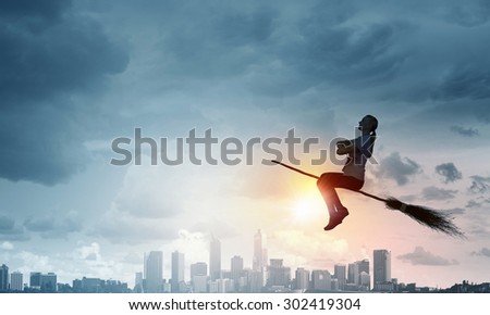 Happy young woman flying in sky on broom