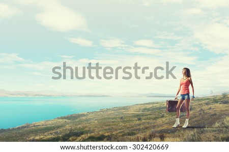 Traveler woman walking with retro suitcase in hand