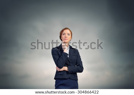 Young thoughtful businesswoman with finger on chin