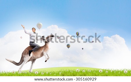 Young pretty fearless woman riding kangaroo animal
