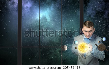 Young businessman and planets of space spinning around
