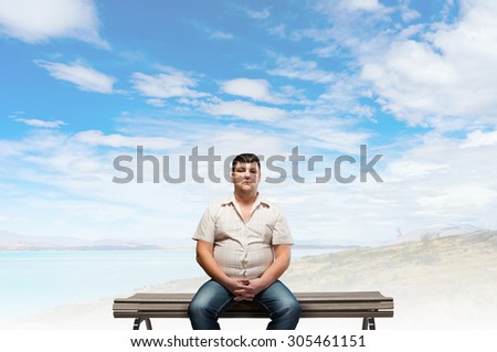 Fat man sitting on bench and looking in camera
