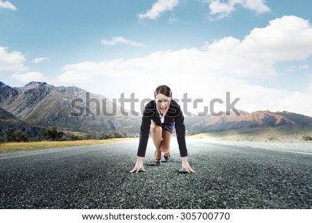 Young determined businesswoman standing in start position