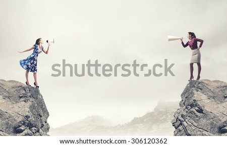 Two women shouting in megaphones at each other