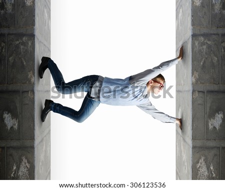 Young man under pressure between two stone walls