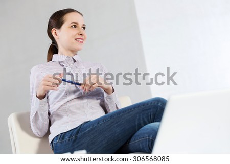 Young pretty girl in casual sitting with pen in hands