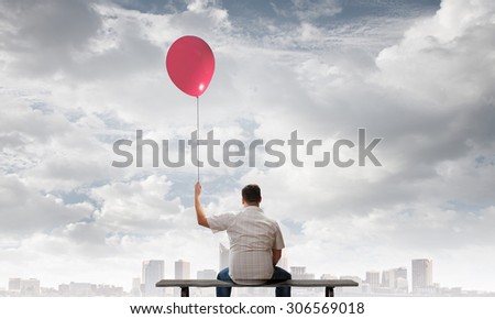Fat man sitting on bench with his back with balloon in hand
