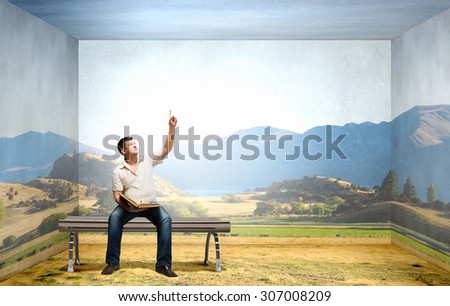 Fat man sitting on bench with book and pointing with finger