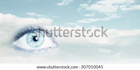 Close up of female eye on blue sky background