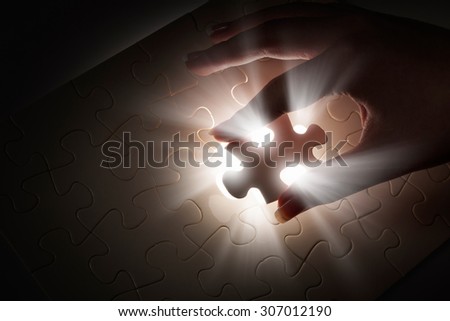 Hand connecting missing jigsaw glowing puzzle piece