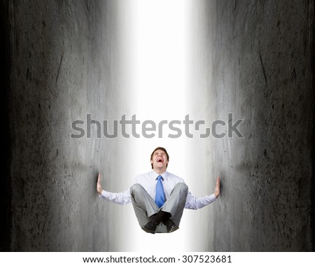 Businessman under pressure between two stone walls