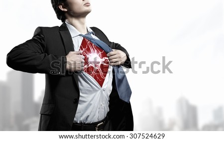 Businessman opening his shirt on chest acting like super hero