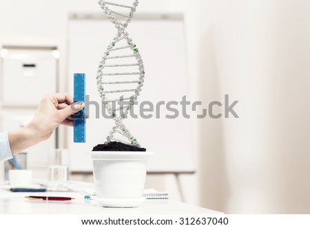 Close up of male hand measuring DNA molecule with ruler