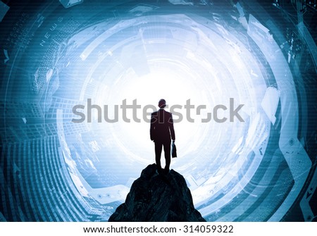 Back view of businessman with suitcase in hands looking at virtual panel