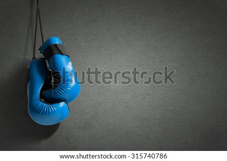 Boxing gloves hanging on nail on wall