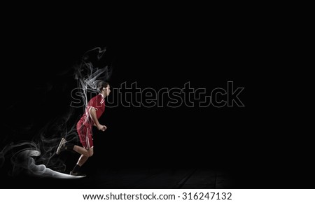 Running man in red sport wear on dark background