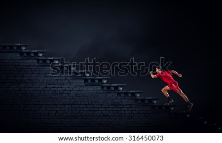 Athlete man in red sport wear running up staircase