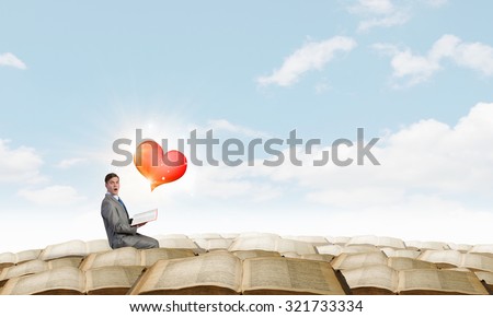 Young emotional businessman with opened book in hand
