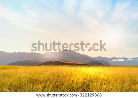 Natural landscape of summer field and high mountain