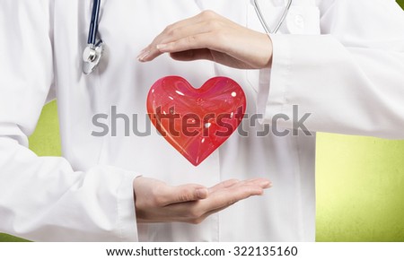 Close up of female doctor holding heart in hands