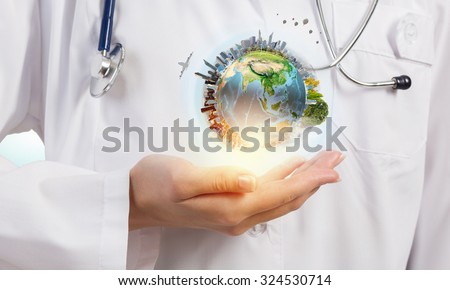 Close up of female doctor holding Earth planet in hands. Elements of this image are furnished by NASA