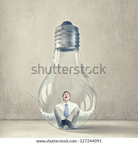 Screaming businessman trapped inside of light bulb