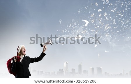 Woman in suit and Santa hat shouting into megaphone