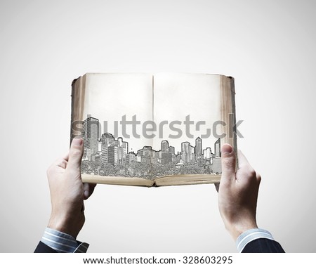 Male hands holding opened book with construction sketches