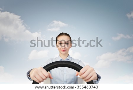 Young smiling pretty woman driving steering wheel