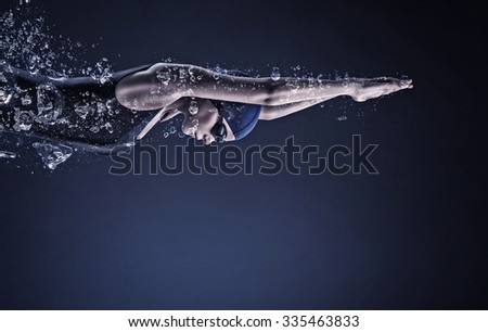 Young woman swimmer in cap and glasses under water