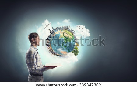 Young man with opened book in hands. Elements of this image are furnished by NASA