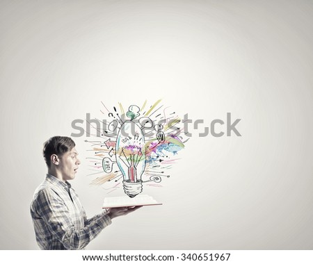 Young emotional guy with opened book in hands