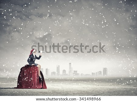 Woman in suit and Santa hat shouting into megaphone