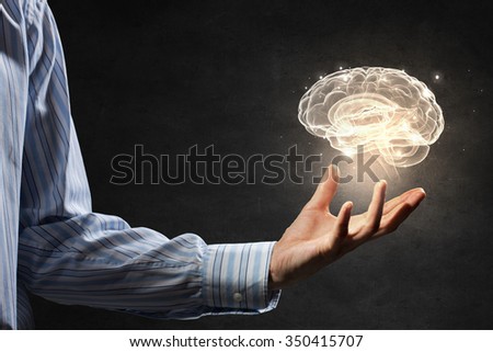Close up of human hand holding brain symbiol