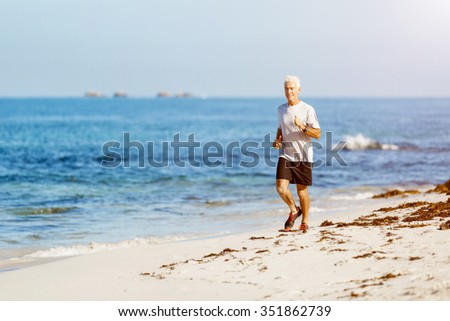 Healthy running man on beach