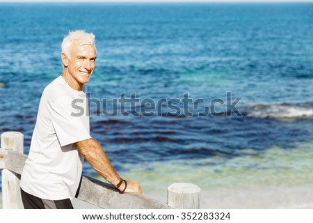 Man standing on beach in sports wear looking fit and happy