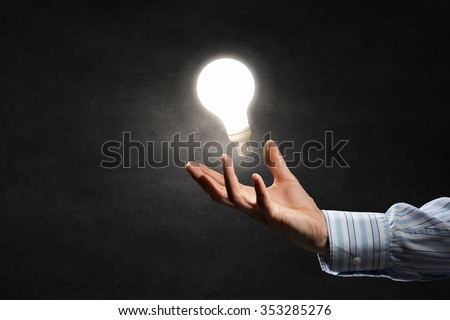 Businessman with illuminated glass light bulb in hand