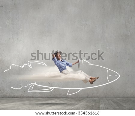 Young happy student girl riding fast drawn rocket