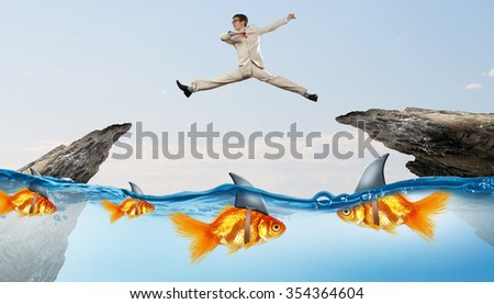 Concept of fake threat when businessman jumping over water gap with shark appear to be goldfish