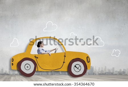 Young humorous woman driving drawn funny car