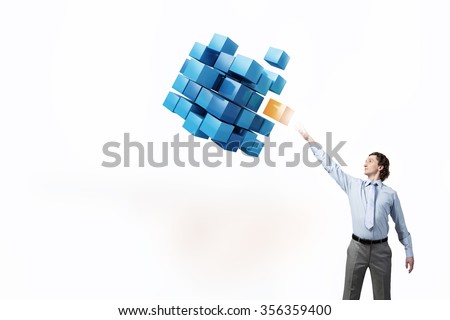 Businessman reaching hand to touch digital cube figure