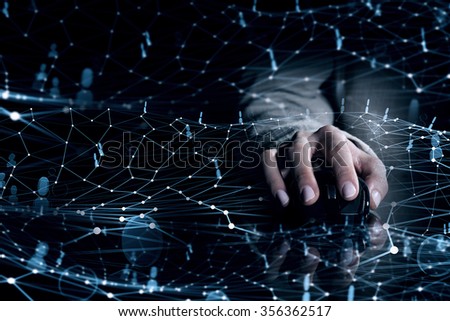Hand of businessman in suit on dark digital background using wireless computer mouse
