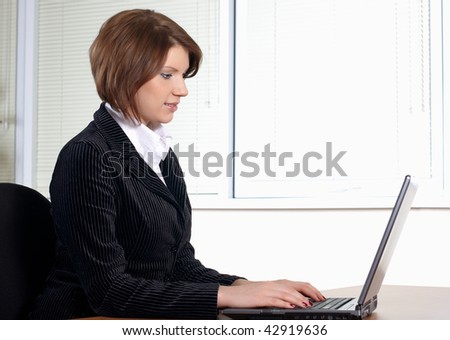 young woman in black dress in office