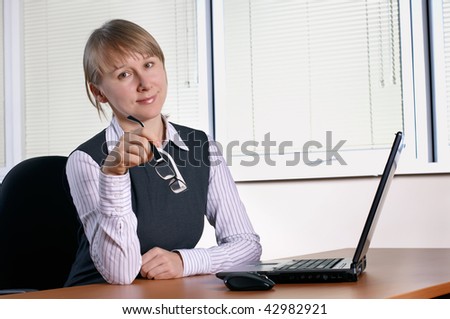 young woman in office with laptop and glasses