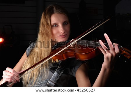 young female play on violin in music study
