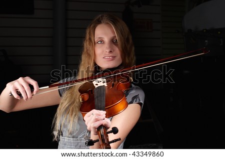 young female play on violin in music study