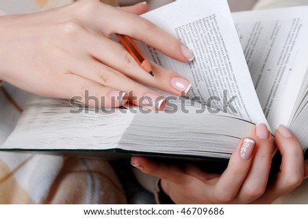 hands of a young girl reading a book
