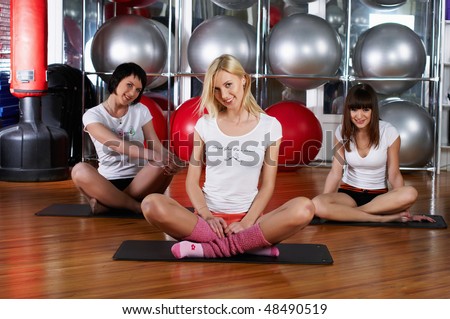 Young charming girls go in for sports in sport hall